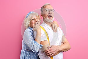 beautiful happy senior couple stand posing together isolated on pink background