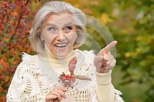 Beautiful happy senior woman in autumn park