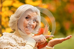 Beautiful happy senior woman in autumn park