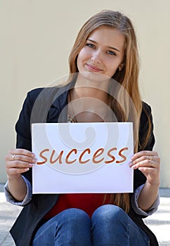 Beautiful, happy, smiling blonde girl with long beauty hair and the inscription, note Success.