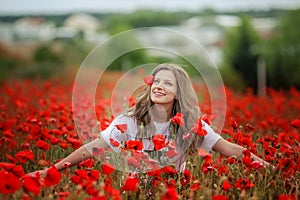 Beautiful happy smiling teen girl portrait with red flowers on head enjoying in poppies field nature background. Makeup