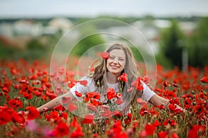 Beautiful happy smiling teen girl portrait with red flowers on head enjoying in poppies field nature background. Makeup