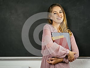 Beautiful happy student in front of blackboard