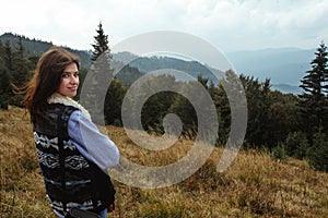 Beautiful happy stylish traveling girl in the mountains on a ba