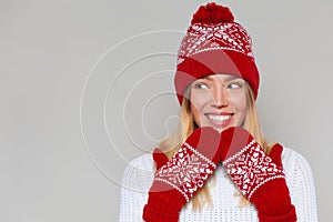 Beautiful happy surprised woman looking sideways in excitement. Excited christmas girl wearing knitted warm hat and mittens