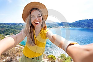 Beautiful happy traveler girl makes selfie while traveling in the mountains. Summer adventure and vacations