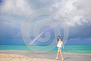 Beautiful happy woman on the beach with beautiful rainbow over the sea