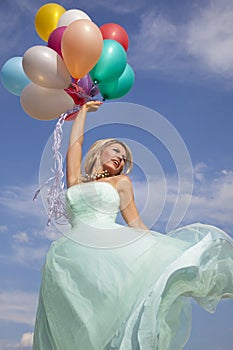 Beautiful, happy woman dancing with balloons