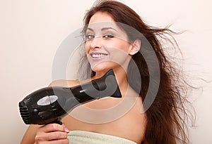 Beautiful happy woman drying brown hair