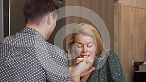 Beautiful happy woman enjoying eating pizza with her boyfriend at home