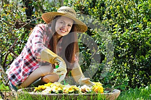 Beautiful happy woman gardening among flowers