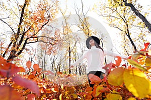 Happy woman having fun in park on autumn sunny day.