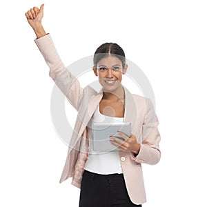 Beautiful happy woman holding arm in the air and smiling