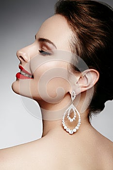 Beautiful happy woman in luxury fashion earrings. Diamond shiny jewelry with brilliants. retro style portrait