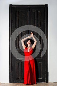 Beautiful happy woman in red dress in interior