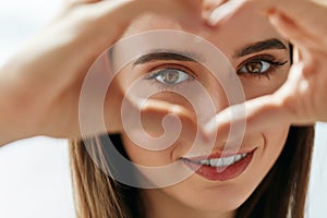 Beautiful Happy Woman Showing Love Sign Near Eyes.