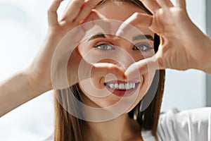 Beautiful Happy Woman Showing Love Sign Near Eyes.