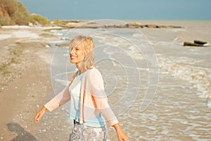 Beautiful happy woman smiling and walking on the sea shore