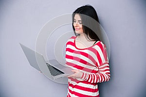 Beautiful happy woman standing with laptop
