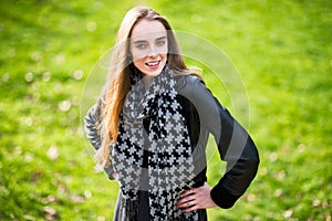 Beautiful happy woman standing outdoors on the green grass