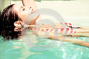 Beautiful happy woman sunbathing relax by rhe pool photo