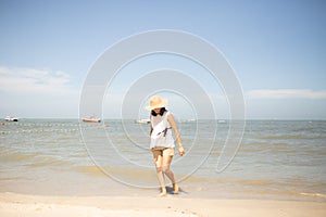 Beautiful happy woman walking down the beach