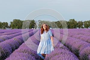 Beautiful and happy woman walks in a lavender field