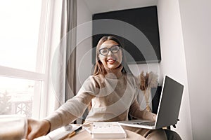 Beautiful happy woman working . Smiling business woman woman wearing eyeglasses in office, using laptop computer