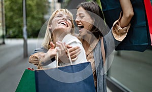 Beautiful happy women with shopping bags walking at the mall