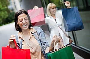 Beautiful happy women with shopping bags walking at the mall