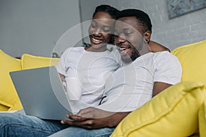 beautiful happy young african american couple using laptop together