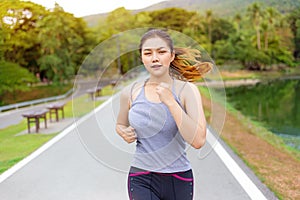 Beautiful happy young Asian woman running for her morning exercise