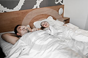 Beautiful happy young couple or family waking up together in bed