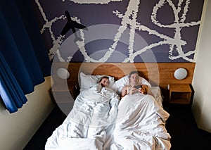 Beautiful happy young couple or family waking up together in bed