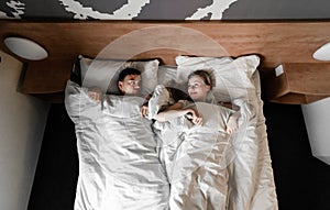 Beautiful happy young couple or family waking up together in bed