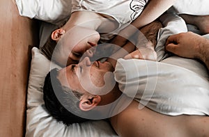 Beautiful happy young couple or family waking up together in bed