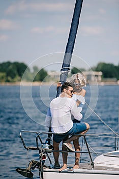 beautiful happy young couple in sunglasses sitting and hugging