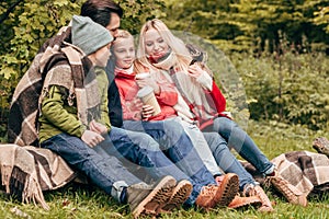 beautiful happy young family drinking from disposable cups while sitting