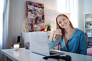 Beautiful happy young girl with laptop sitting and smiling, online dating concept.