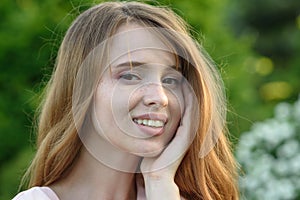 Beautiful and happy young girl walks in the park and enjoys life