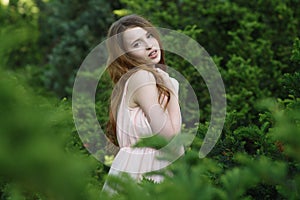 Beautiful and happy young girl walks in the park and enjoys life