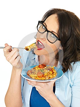 Beautiful Happy Young Hispanic Woman Eating a Plate of Tomato and Basil Fusilli Pasta