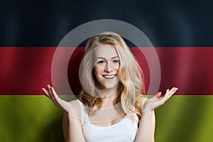 Beautiful happy young woman against the germany flag background. Live, education and work in United Germany