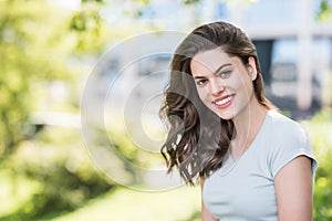 Beautiful happy young woman closeup portrait. Pretty model girl with perfect fresh clean skin smiling  outdoors