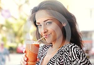 Beautiful happy young woman drinking healthy smoothie juice outdoor background. Closeup portrait