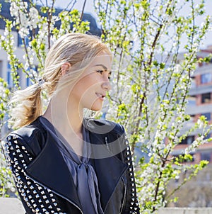 Beautiful happy young woman enjoying smell in a flowering spring