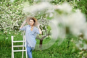 Beautiful happy young woman enjoying smell in a flowering spring