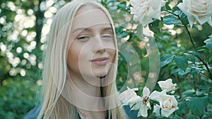 Beautiful happy young woman enjoying smell flowering spring garden