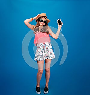 Beautiful happy young woman listening to music and dancing