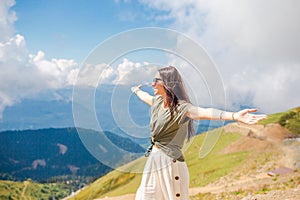 Beautiful happy young woman in mountains in the background of fog